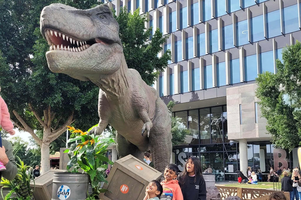 Family posing for a picture with a dinosuar