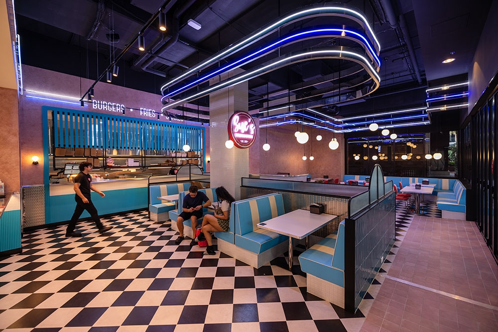 Two people sitting on a booth inside Sue's Burgers and Shakes Woolloongabba