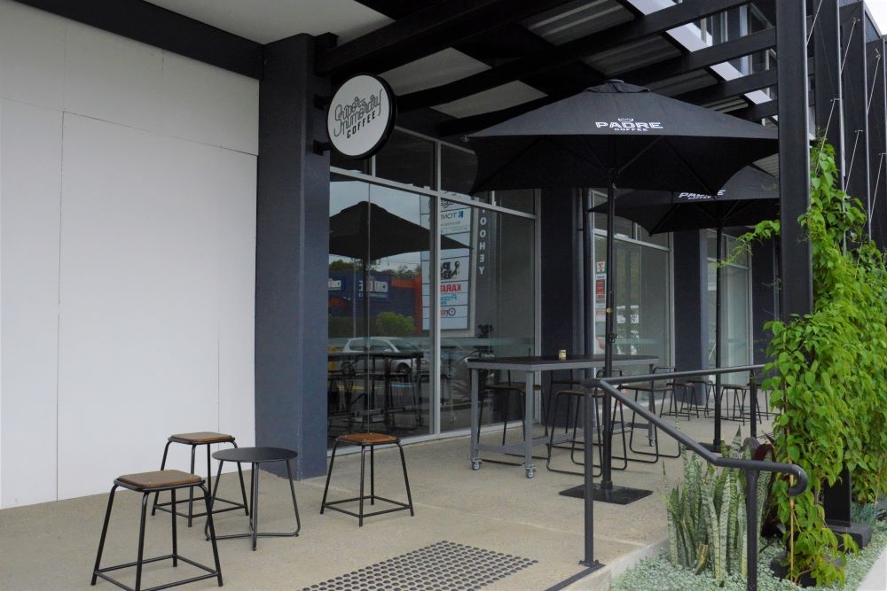 Entrance with tables and chairs outside Supernumerary Coffee shop