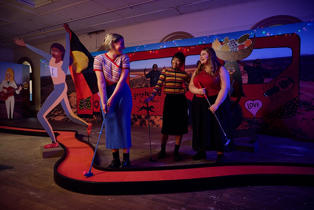 Three women playing mini golf at Swingers - The Art of Mini Golf