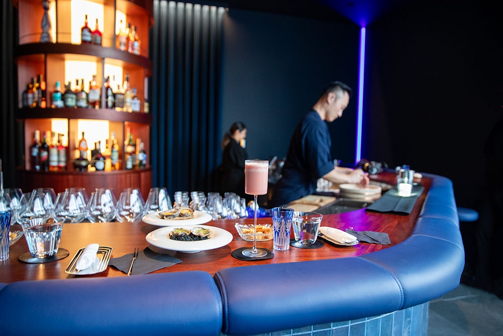 Plates of food & cocktail on bar at +81 Aziome Bar