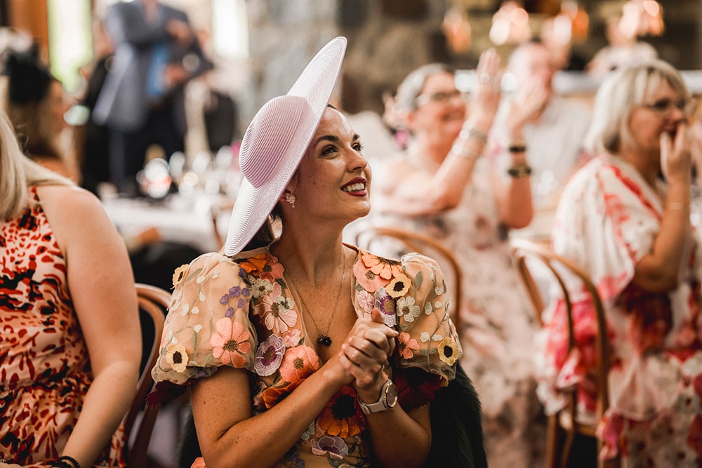 Women in hat at table clapping Sirromet