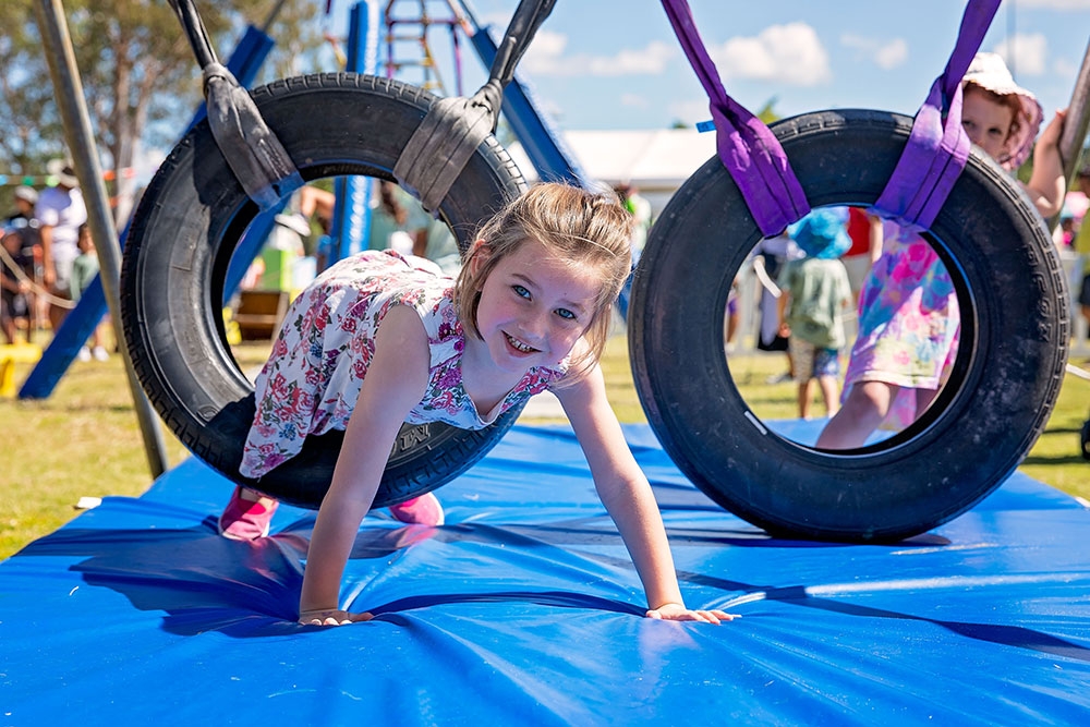 Girl playing on tyre ImagiNation Children's Festival