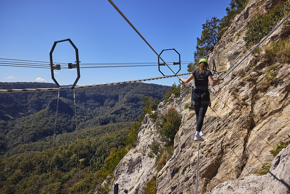 Woman on The Arête Via Ferrata Tour at Happitat Adventure Park