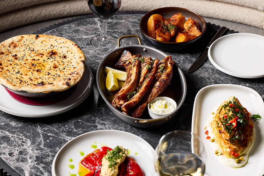 Plates of food with lamb dish in centre 