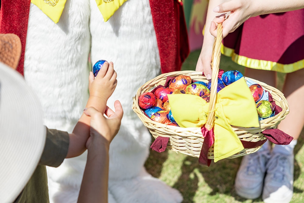 Child getting handed an Easter egg at the Easter Weekend at Roma Street Parkland
