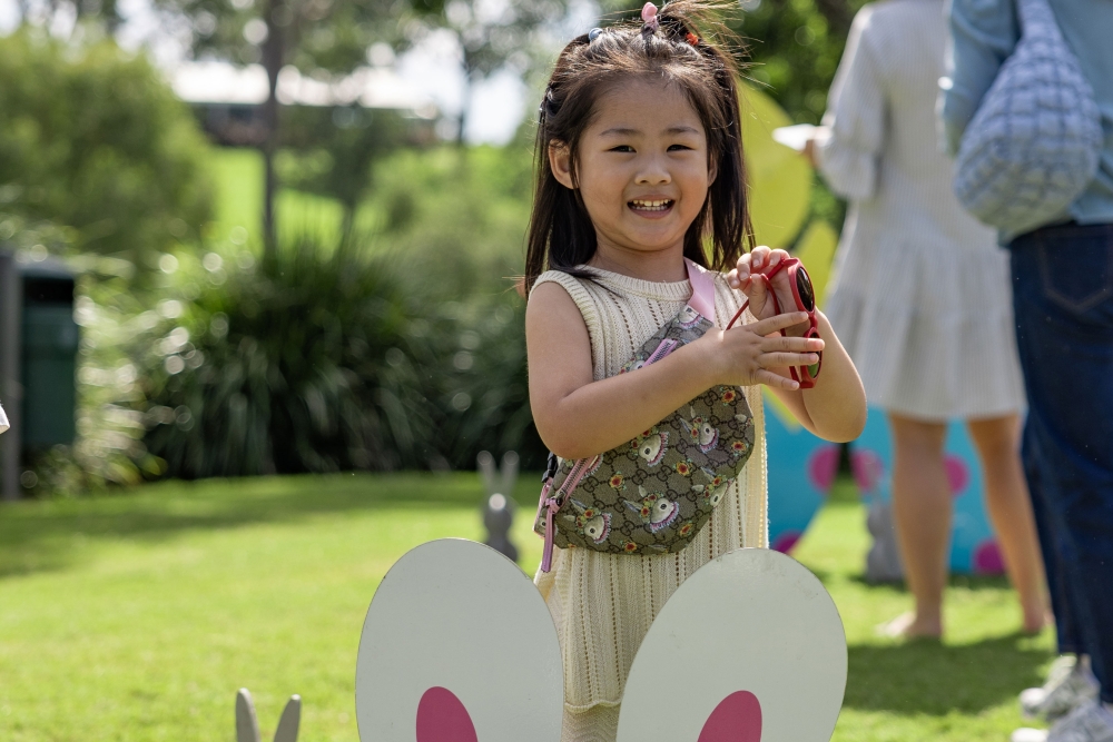 Child holding an Easter egg at the Easter Weekend at Roma Street Parkland