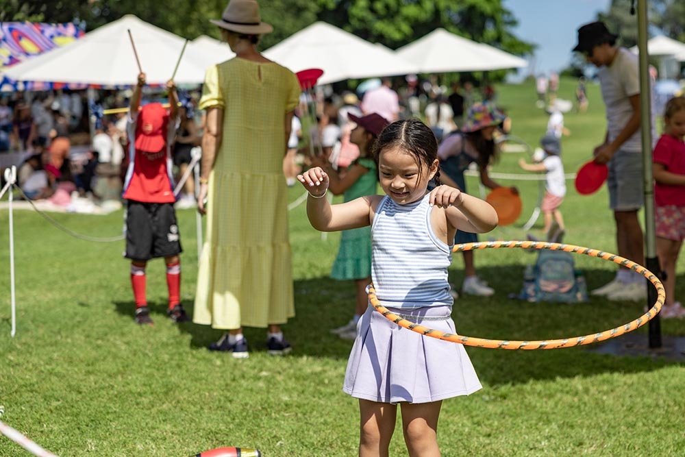 Child hula hooping at the Easter Weekend at Roma Street Parkland    