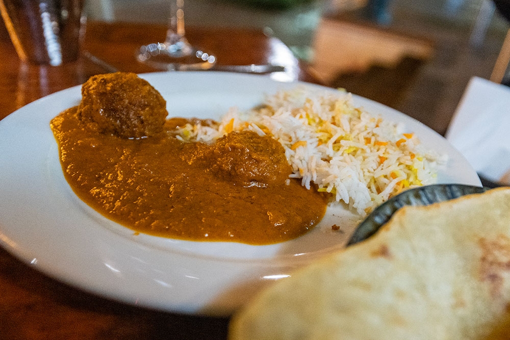 Curry and rice in a bowl at A Night in India Milton