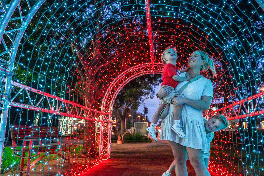 Woman walking through lights Christmas On Redlands Coast