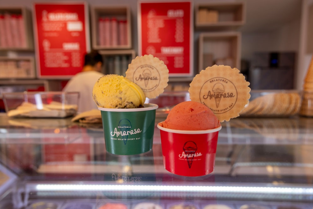 Two cups of ice cream sitting on display counter at Amoroso Gelateria Paddington