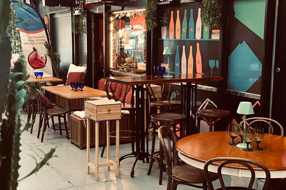Tables and chairs in arcade outside Arcade Wine