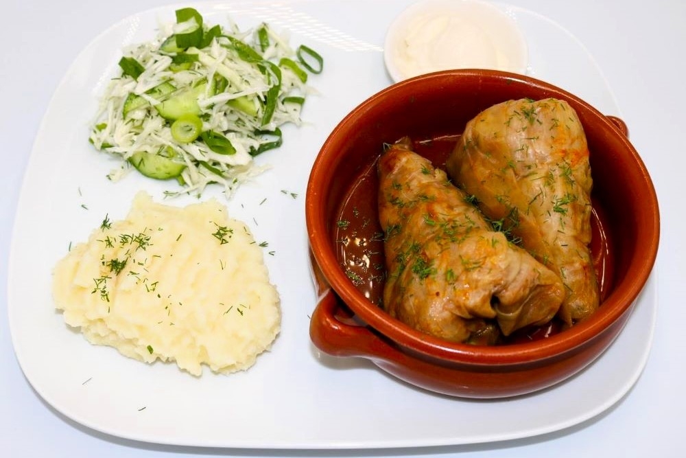 Bowl of cabbage rolls filled with beef and rice served with mashed potato and sour cream at BK Pizzeria & Cafe
