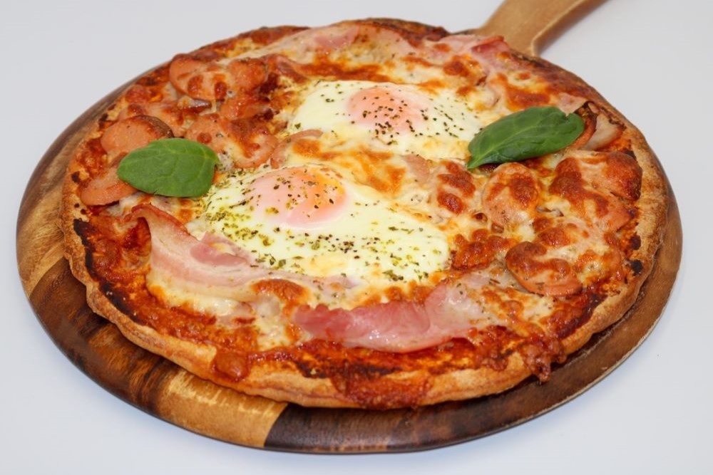 Pizza on a wooden serving board at BK Pizzeria & Cafe 