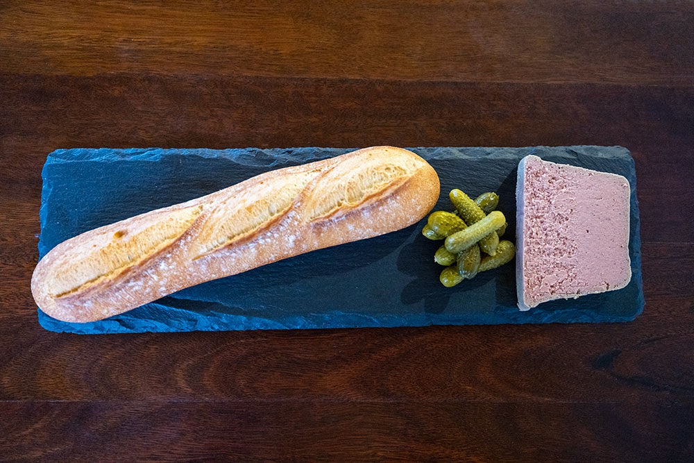 Baked baguette with pate on a plate at Barrels & Stills Woolloongabba