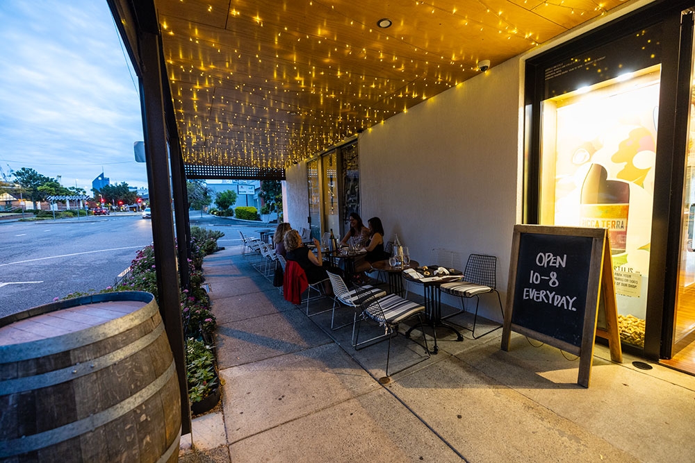 People sitting on tables outside Barrels & Stills Woolloongabba