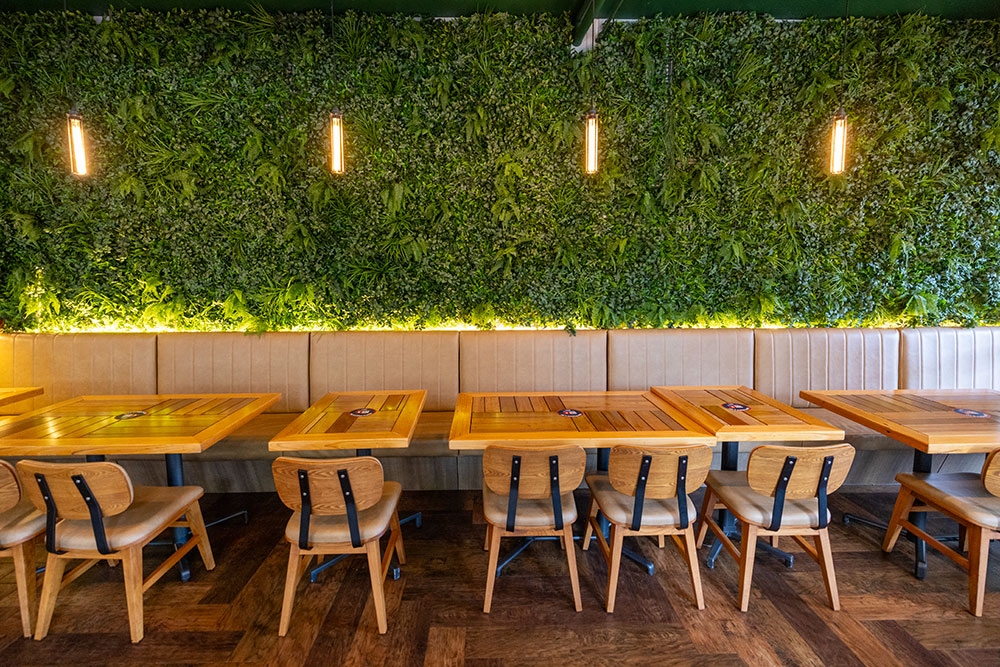 Contemporary timber space with banquette seating along one wall inside Benny's American Burger