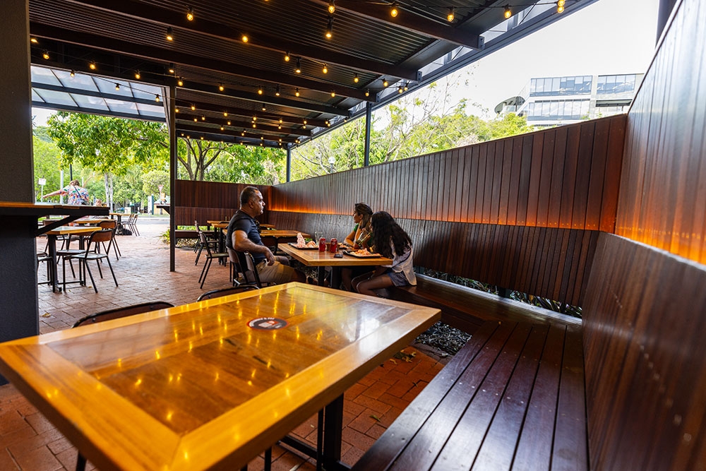 Customers sitting at covered pavilion at Benny's Burgers