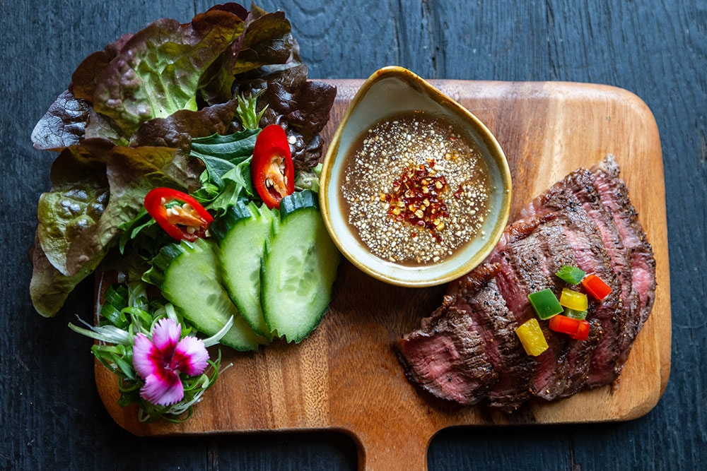 Wooden platter of crispy deep-fried Pork Belly (Moo Krob) with chef's special dipping sauce at Boo's Kitchen, Woolloongabba