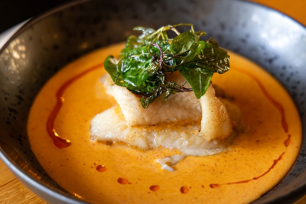 Plate of yellow crab curry with pieces of blue swimmer crab at Boo's Kitchen, Woolloongabba