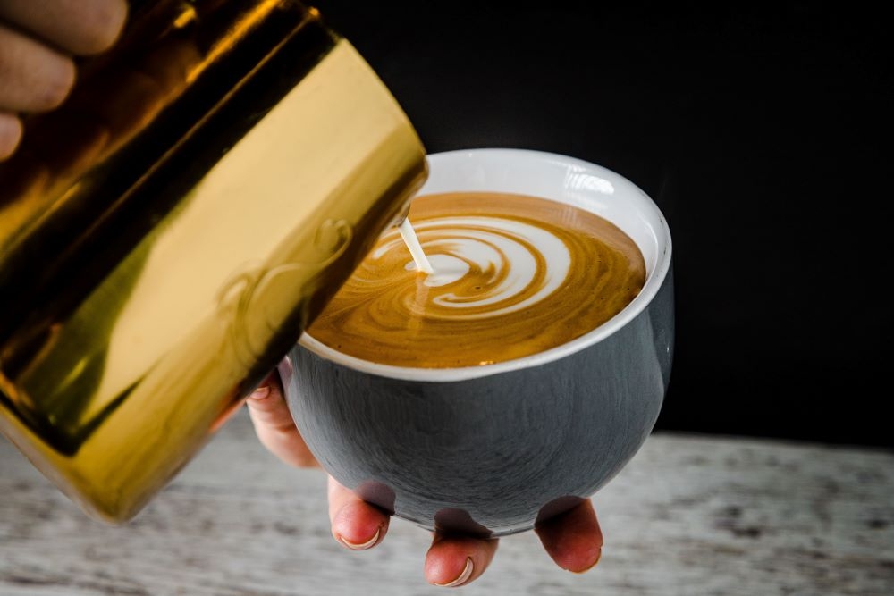 Handing holding a coffee in a mug at Coffee Head Co 