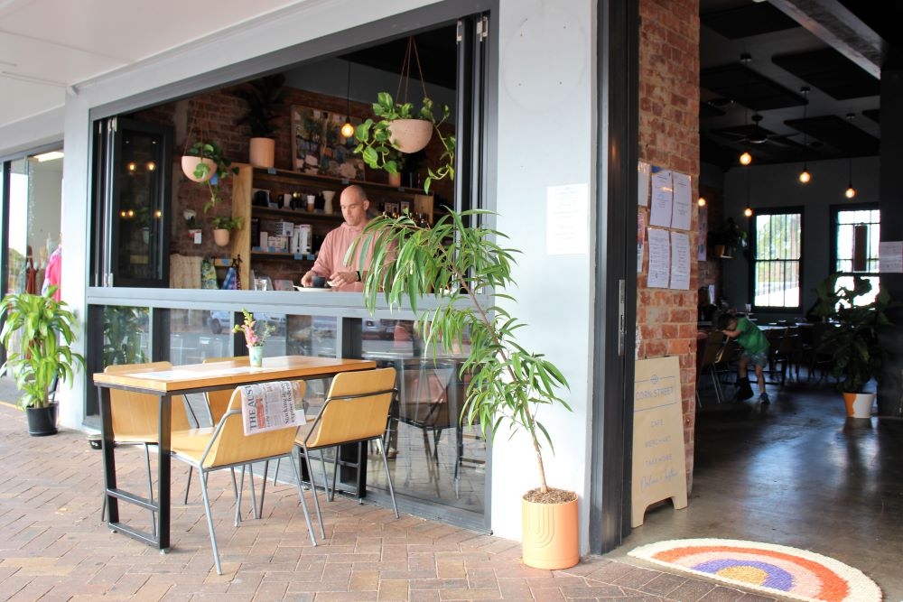 Man sitting at open window inside Corn Street, Ashgrove 