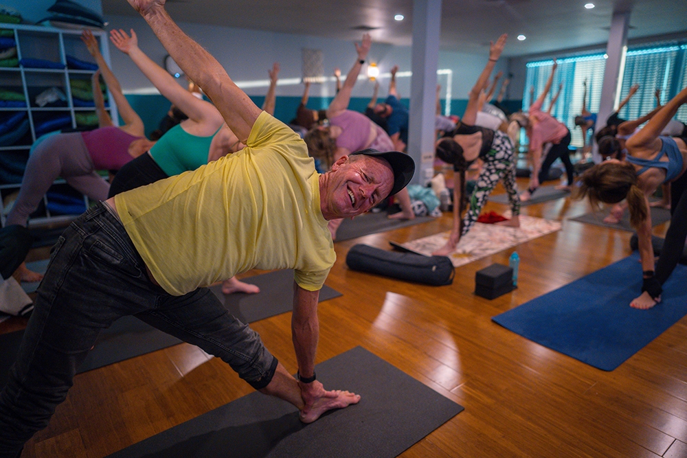 man doing yoga in a group