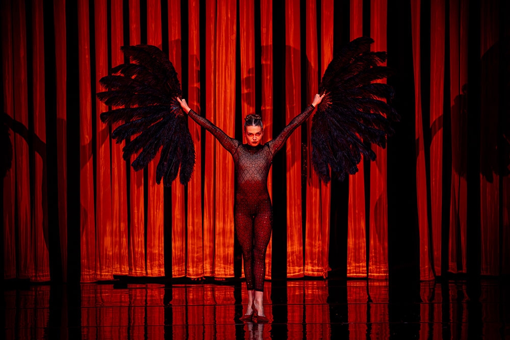 Performer holding feathers on stage in Circa's Duck Pond