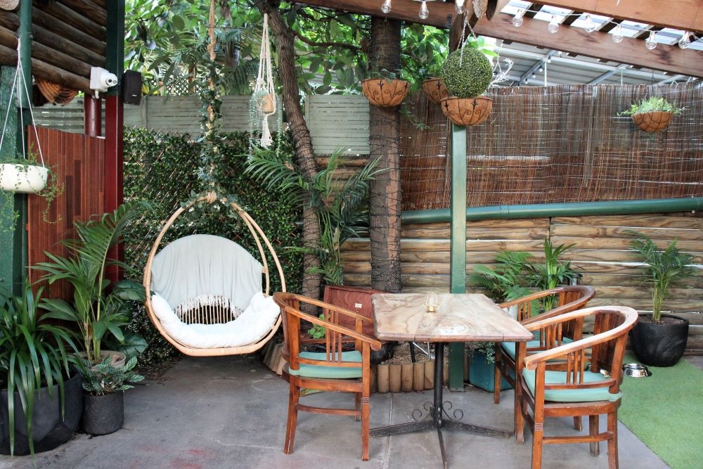 Tables and chairs inside courtyard at The Fourth Monkey Bar, West End 