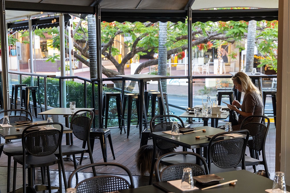 Woman seated on terrace at Hono Grill Milton