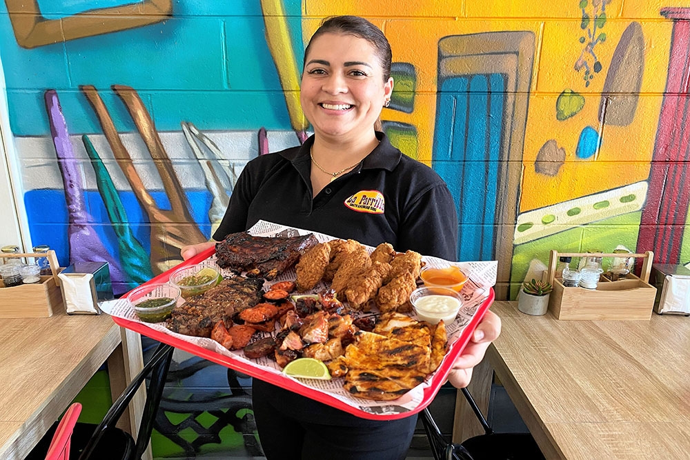 Waiter holding food platter La Parrilla North Ipswich