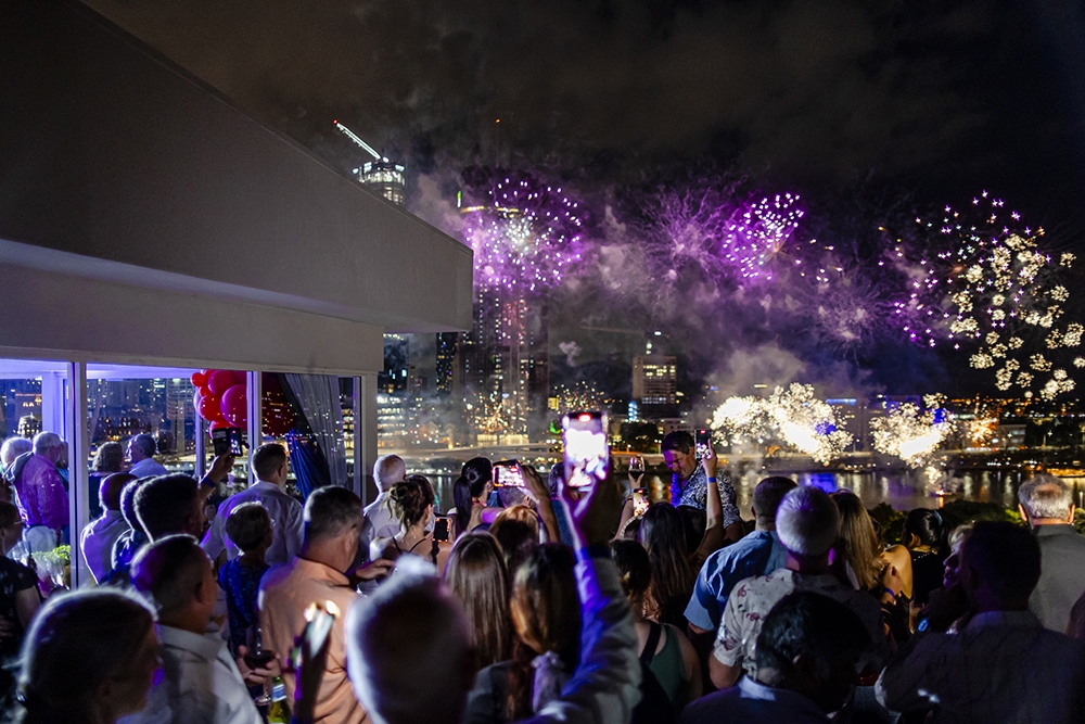 People looking at NYE fireworks on the river from Rydges South Bank