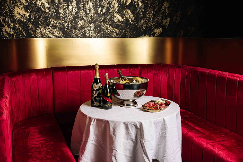Red velvet booth and table inside House of Vice Fortitude Valley