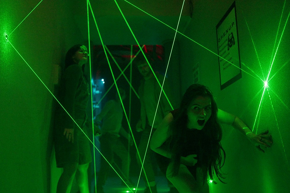 People dodging green lasers at Project Immersive's Area 1 Escape Rooms