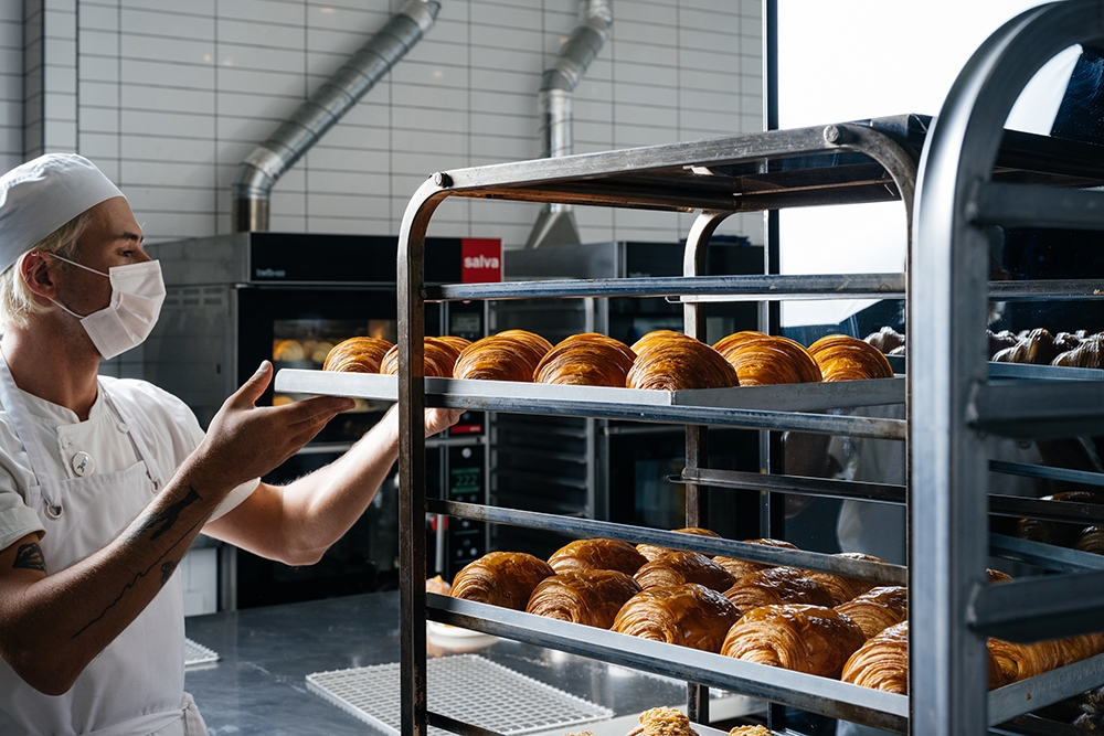 Baker removing croissants from oven at Lune Croissanterie South Brisbane