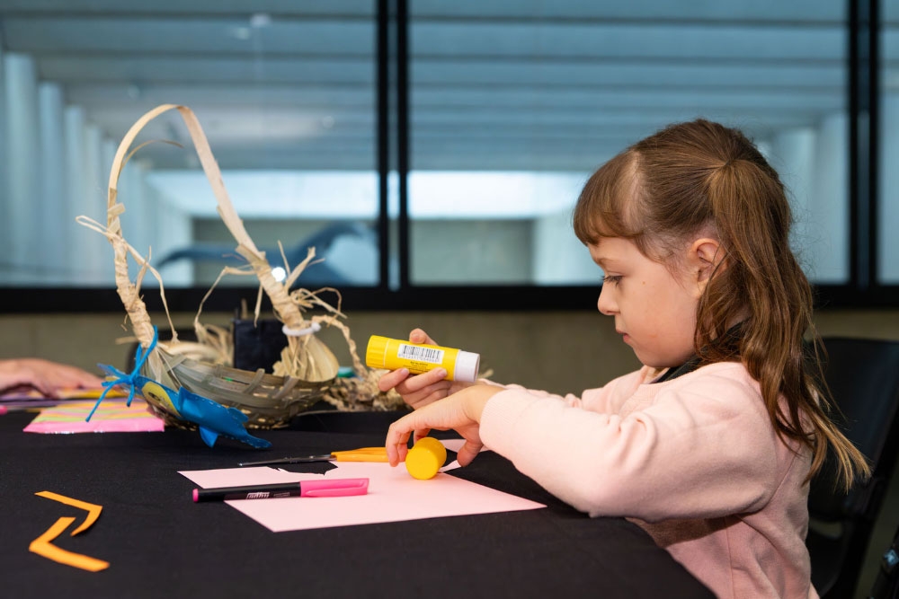 Girl making dilly bag at Qld Museum