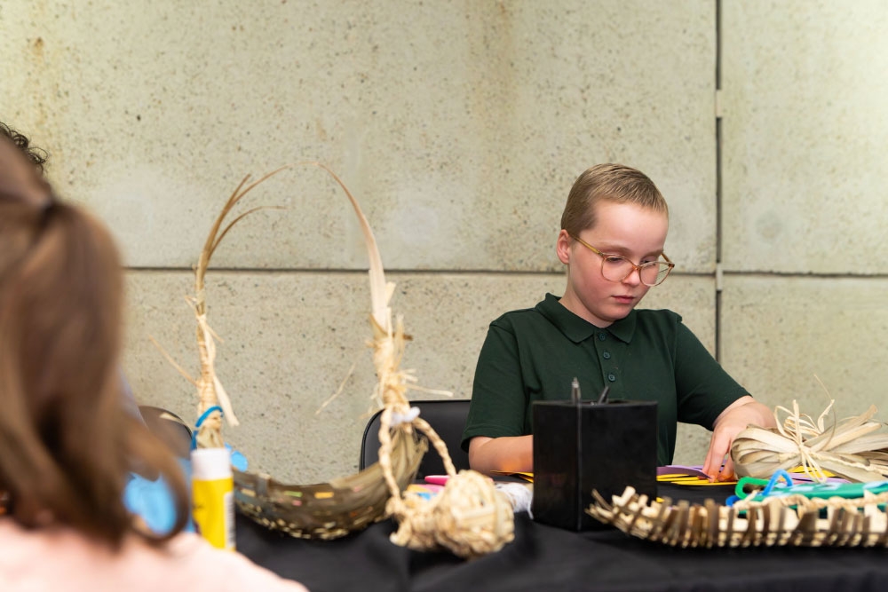 Child making dilly bag at Qld Museum