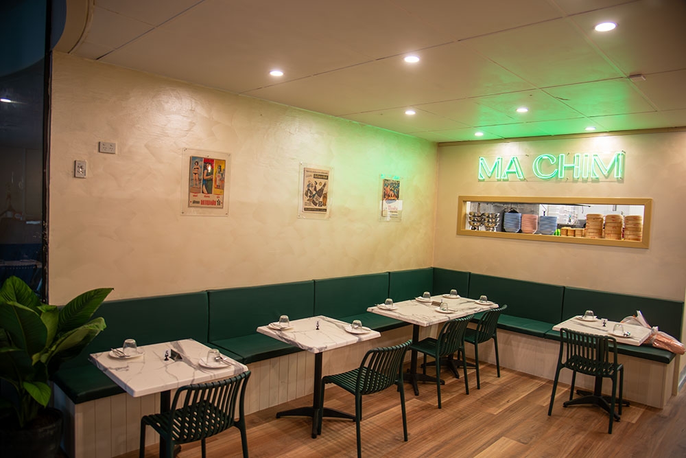 Tables set for dining inside pastel-hued interior of Chim Rosalie