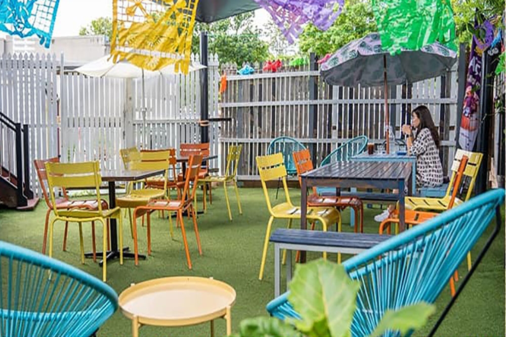 Tables and chairs in courtyard outside Mama de Luna Wilston