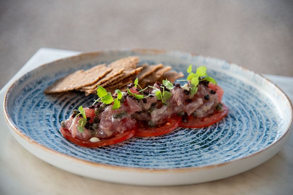 Plate of Mooloolaba yellow fin tuna, local tomatoes, Moroccan lemon creme fraiche, candied olive