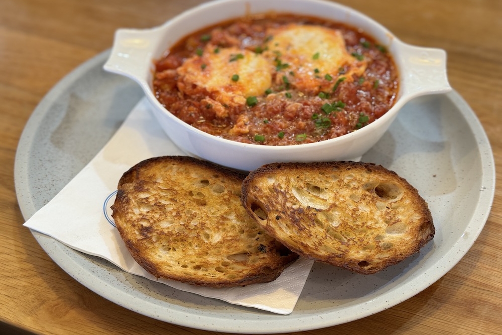 Eggs Puttanesca fusion of soft poached eggs and an Italian-inspired sauce at Merlo Coffee Bowen Hills Torrefazione
