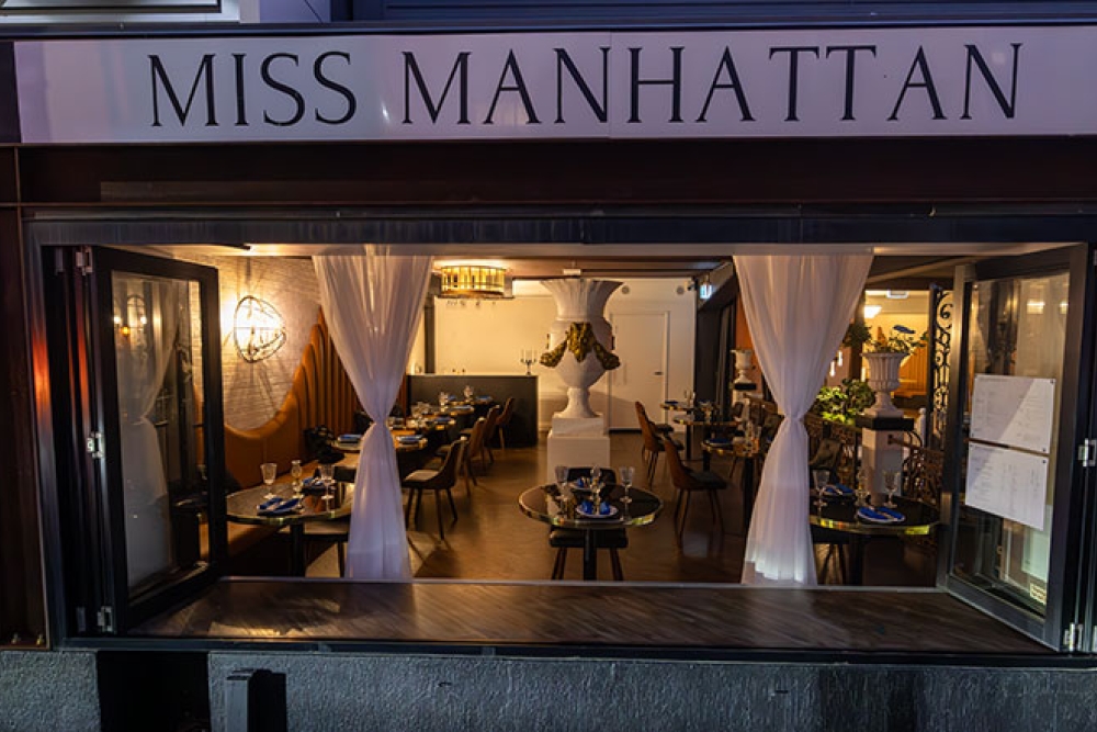 View of dining area through window at Miss Manhattan Newstead