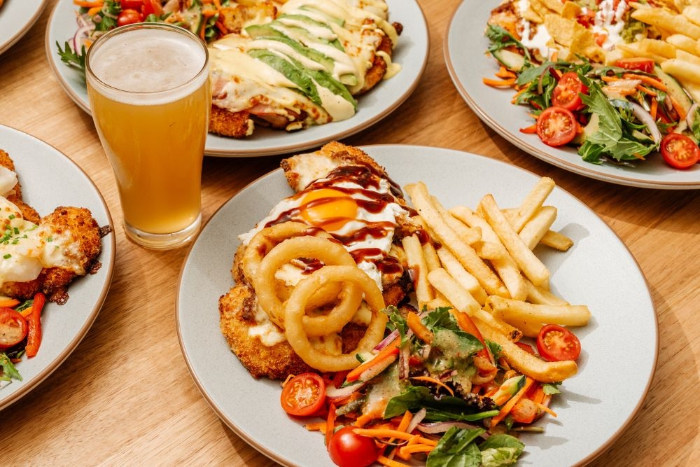 Plates of food and a glass of beer at Morayfield Tavern 
