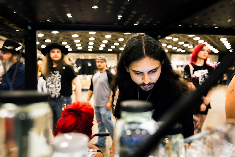 Man looking at specimen in jar at the Oddities & Curiosities Expo