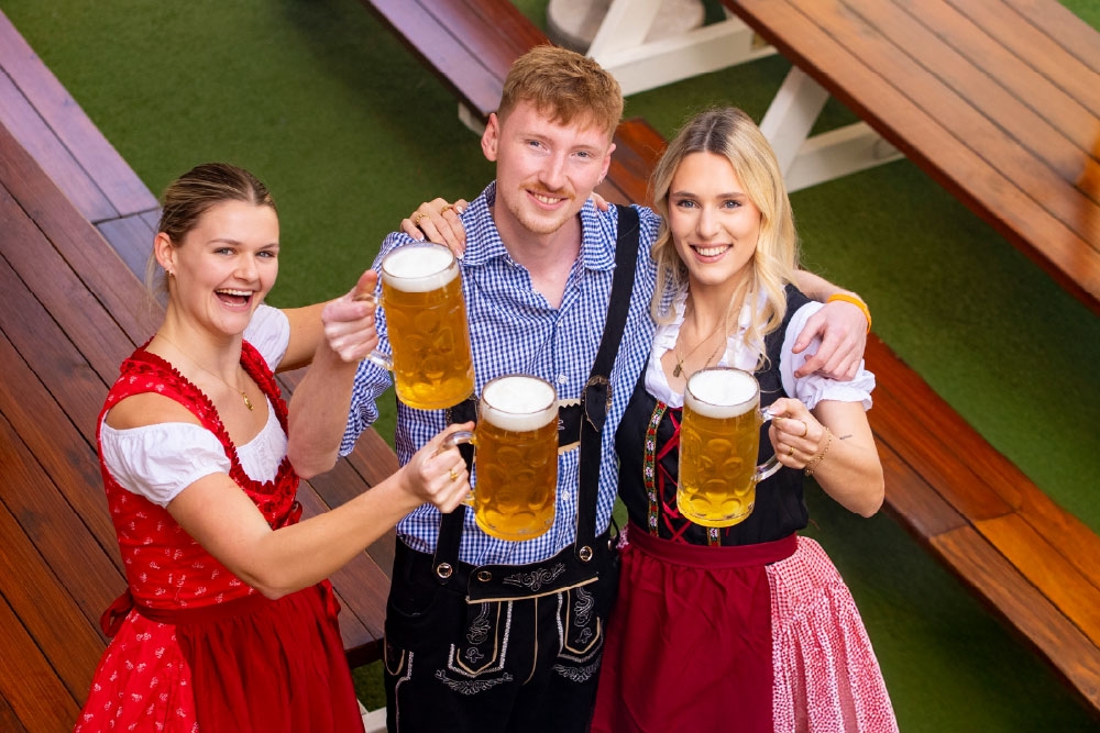 People holding beers at Oktoberfest at The Hills
