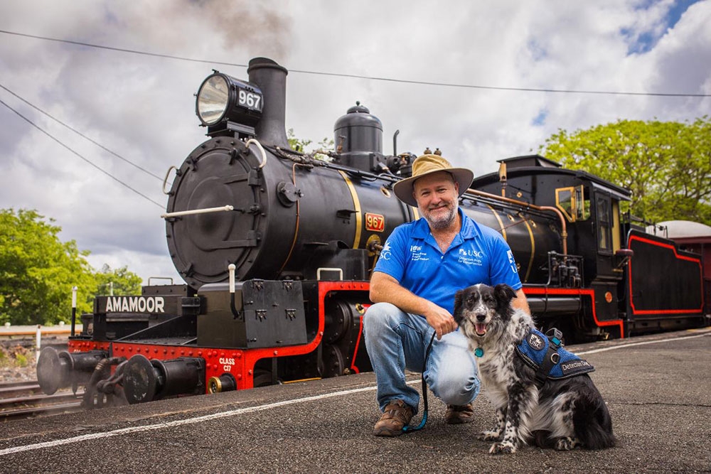 Man with dog in front of Mary Valley Rattler vintage train