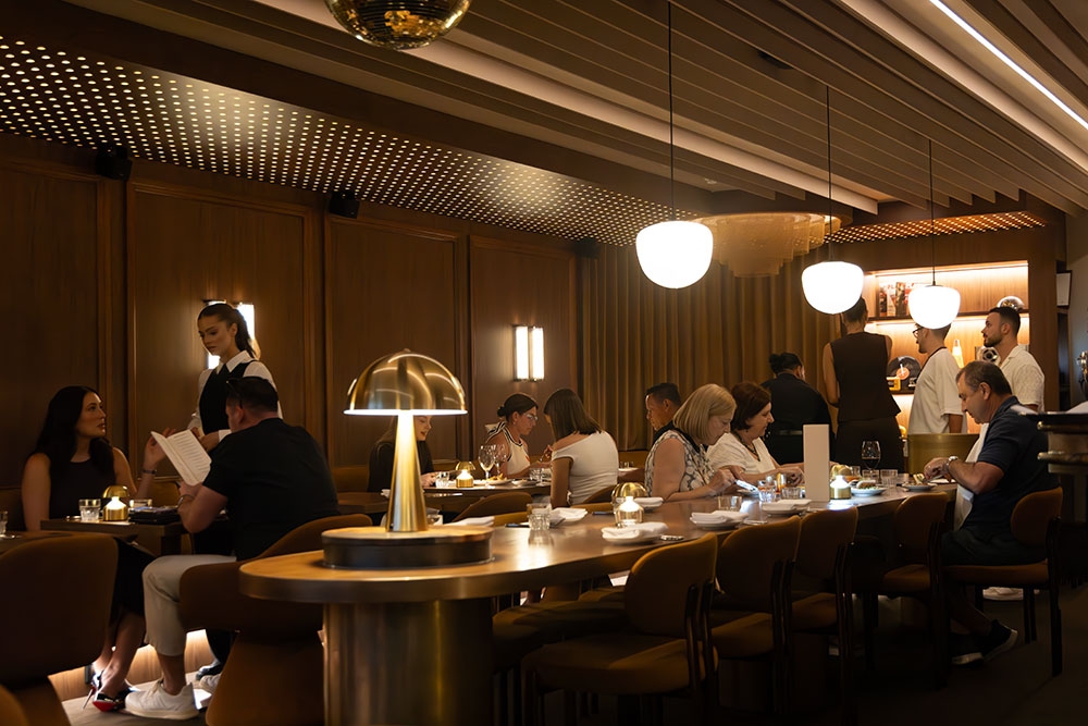 Diners at centre tables and banquettes in Penelope Bistro + Bar