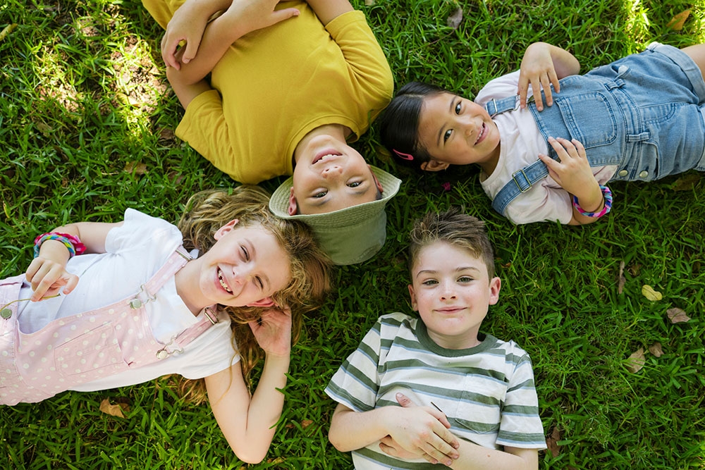 Four children lying on the ground at Playtopia, Roma Street Parkland 
