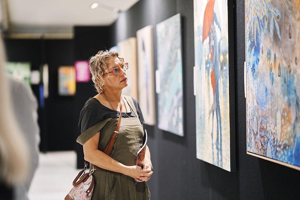 Person looking at paintings Recovered Futures Art Exhibition Brisbane City