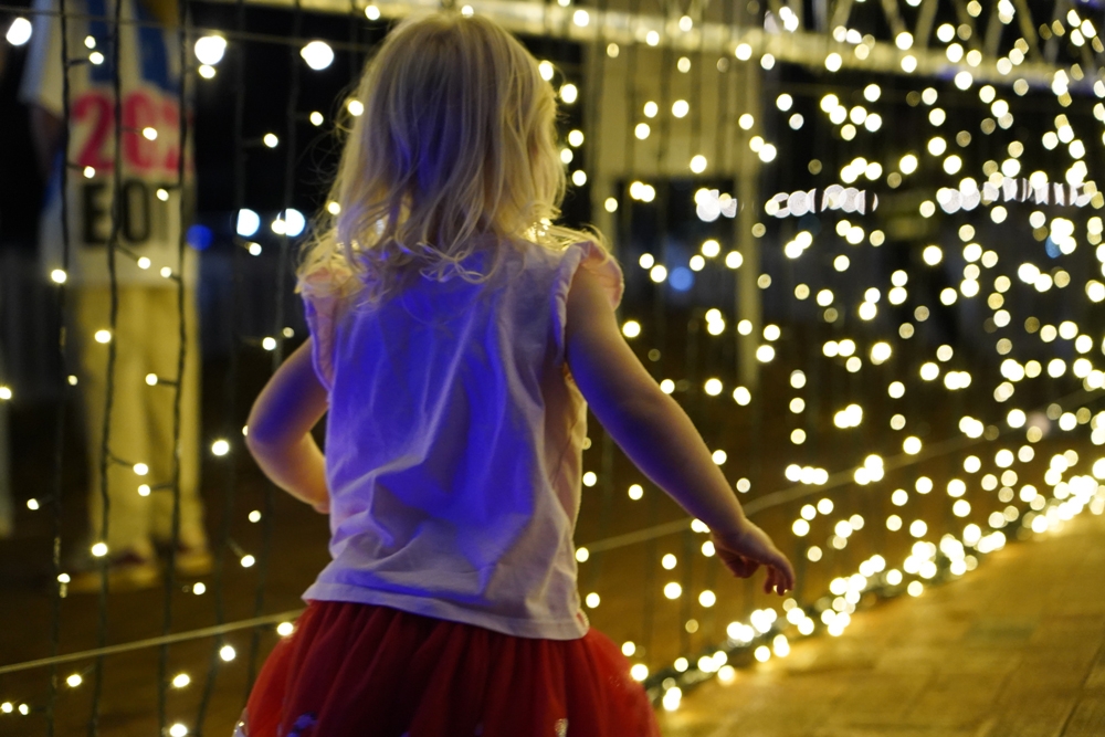 A girl walking in front of Christmas lights, Christmas On Redlands Coast